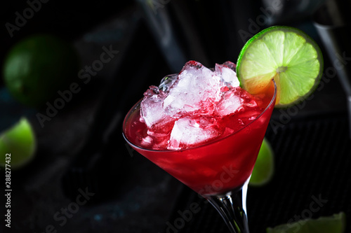 Watermelon cobler, alcoholic cocktail with vodka, lemon juice, mint, lime and crushed ice, metal bar tools, dark background photo