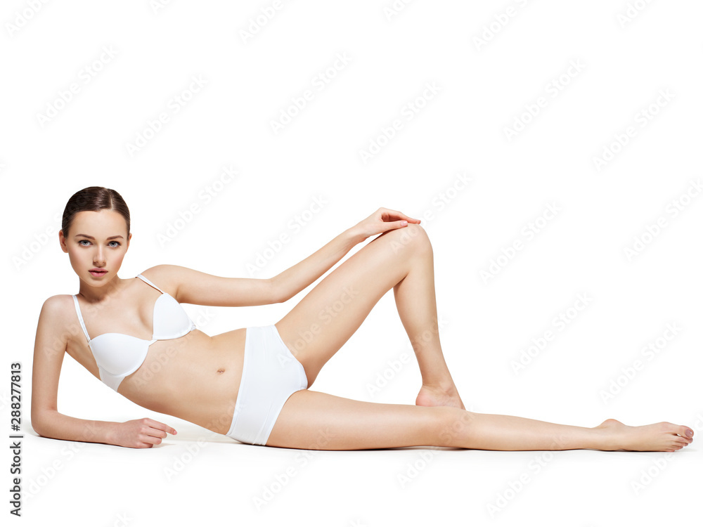 Beautiful woman with perfect body lying on white
