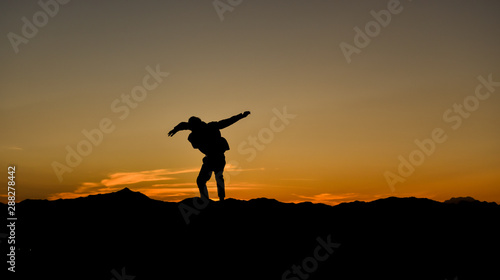 Silhouette of a jumping man at sunset, Concept lifestyle freedom vacation travel.