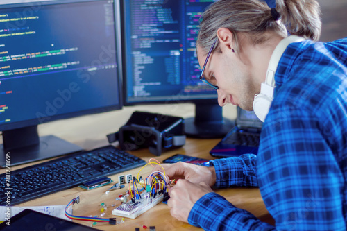 Принти на полотні Developer is connecting breadboard to microcontroller for creating prototype of electronic device
