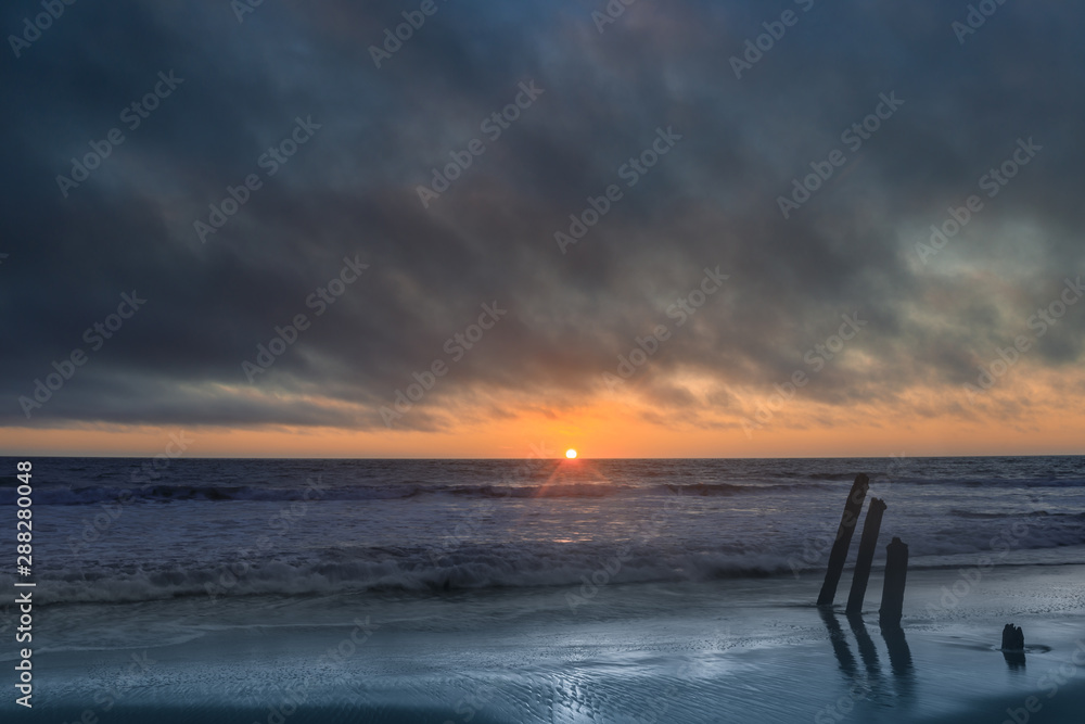 Sun peeking thru moving ominous clouds. Fort Funston, San Francisco, California, USA.