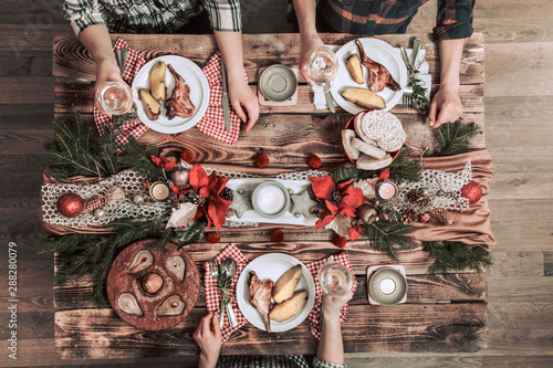 Flat-lay of friends hands eating and drinking together. Top view of people having party, gathering, celebrating together at wooden rustic table