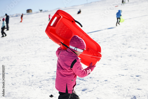 Little girl sledding at Sierra Nevada ski resort.