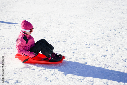 Little girl sledding at Sierra Nevada ski resort.