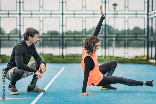 Young Female Athlete Exercising with Personal Fitness Trainer