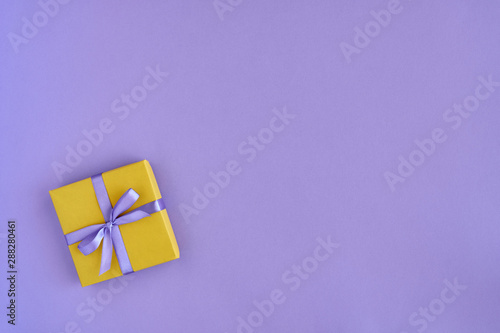  Gift box with ribbon and bow on color background and space for text. Top view