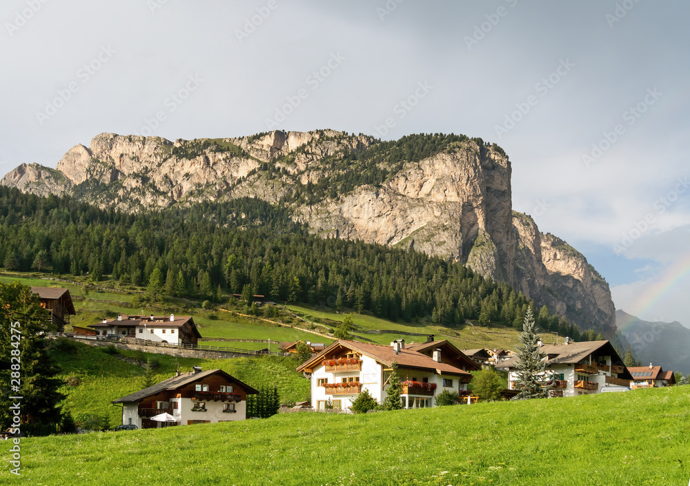 Dolomites view, with rainbow edge. Selva di Val Gardena, Italy, after rain with genuine rainbow. In Alto Adige, South Tyrol. Dolomites view, with rainbow edge. Selva di Val Gardena, Italy, after rain with genuine rainbow. In Alto Adige, South Tyrol.