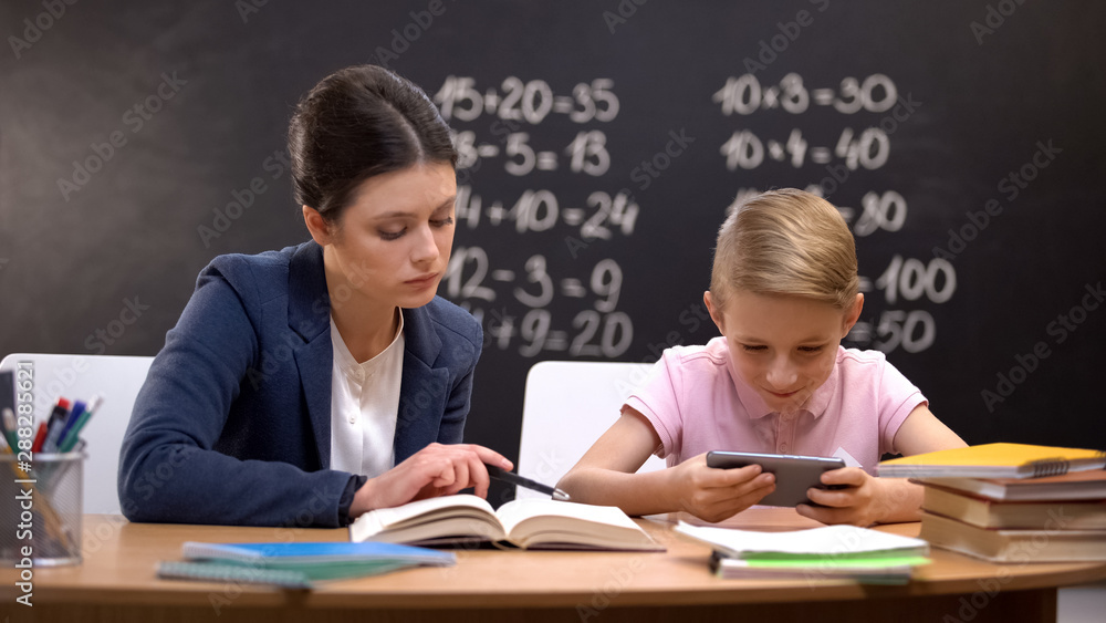 Schoolboy playing smartphone ignoring teacher during private lesson, disrespect Schoolboy playing smartphone ignoring teacher during private lesson, disrespect
