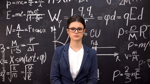 Serious woman physicist completing complex theorem and carried out calculations