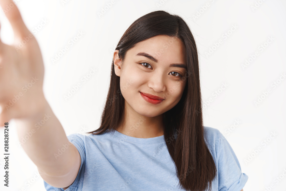 Tender cute happy brunette asian girl record video message extend arm forward hold camera smartphone smiling broadly taking lovely selfie summer vacation stand white background Tender cute happy brunette asian girl record video message extend arm forward hold camera smartphone smiling broadly taking lovely selfie summer vacation stand white background