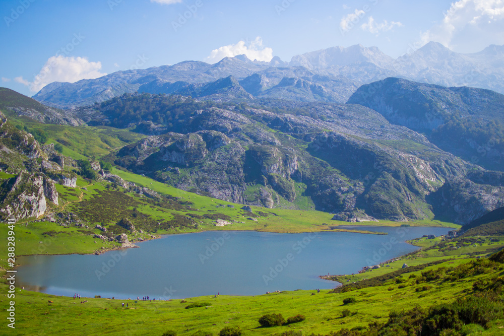 Nice views of Ercina Lake in Covadonga, Asturias, Spain. Green grassland with a glaciar lake and mountains at the background