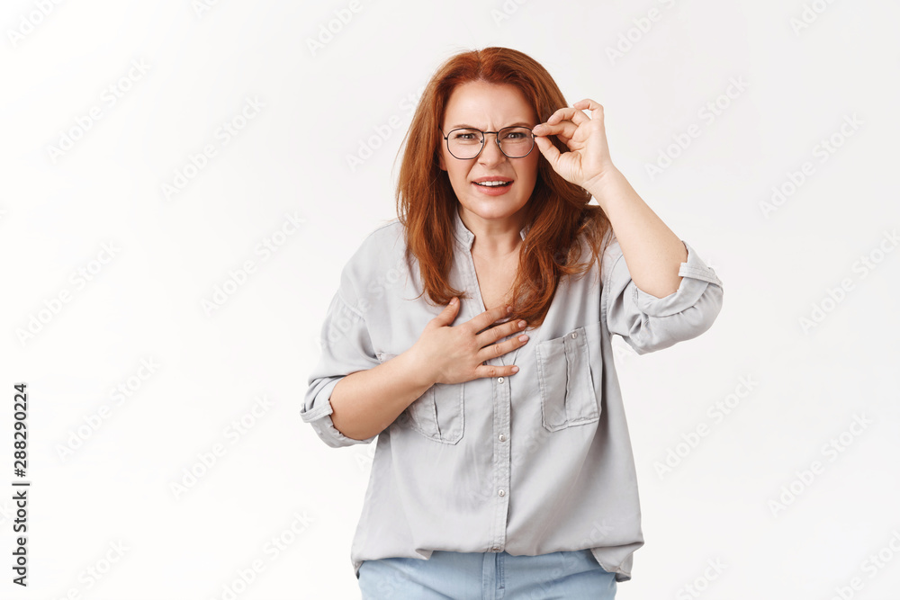 Omg you scared me. Intense unsure redhead middle-aged woman bad sight hold hand heart worried squinting look distance uncertain cannot see clearly standing perplexed stare confused white background Omg you scared me. Intense unsure redhead middle-aged woman bad sight hold hand heart worried squinting look distance uncertain cannot see clearly standing perplexed stare confused white background