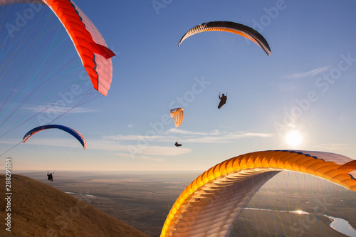 Paraglide with a paraglider in a cocoon against the background of fields of the sky and clouds. Paragliding Sports photo