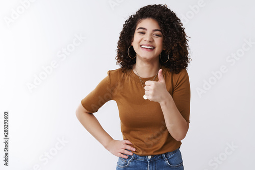 Good thanks. Happy charismatic laughing young attractive girl curly dark hair show thumb up smiling satisfied approve awesome great deal like cool choice picking outfit friend date, white background