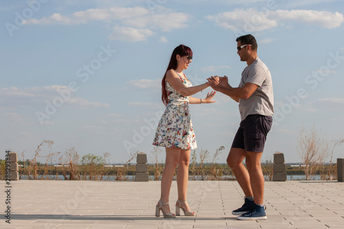 Passionate elegant young couple latino dancers in tango in the park, romantic and sporty lifestyle