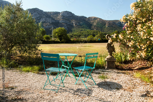 Set of table and two blue chairs in the garden with amazing mountain view. Provence France.