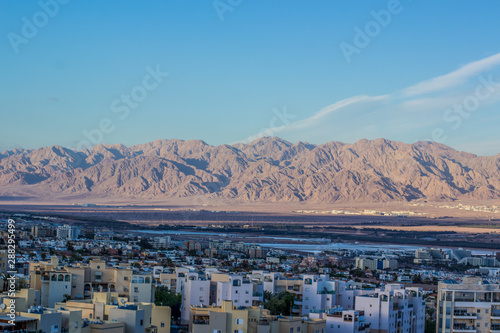 Israeli city Eilat top view from drone with living houses foreground and desert mountain ridge Middle East scenery landscape background 