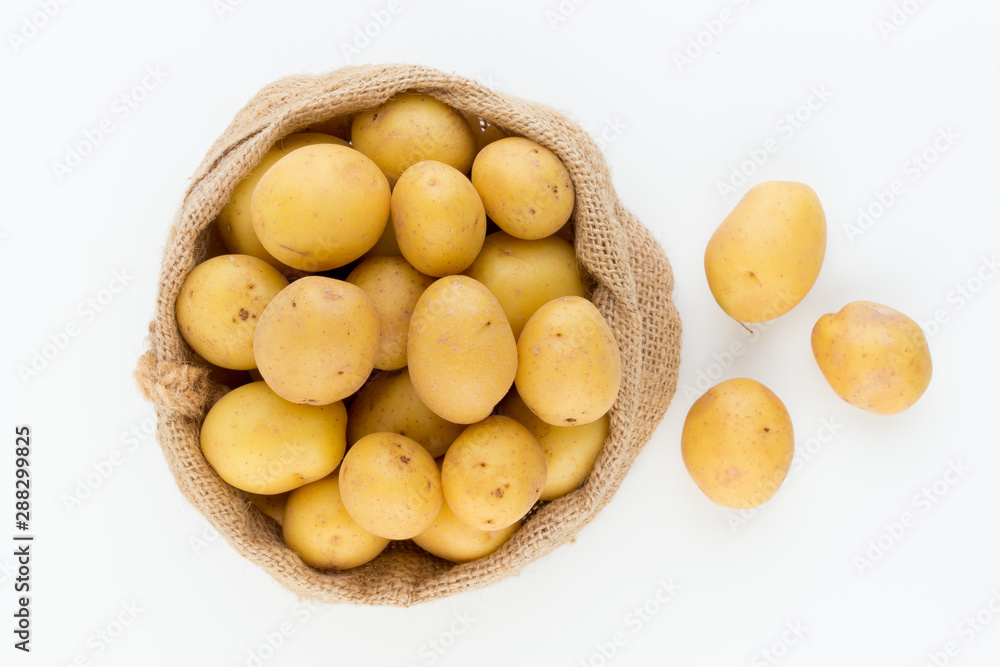Sack of fresh raw potatoes on wooden background, top view Sack of fresh raw potatoes on wooden background, top view