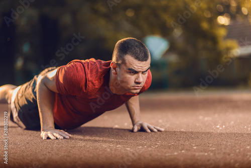 Young athlete exercising push-ups outdoors