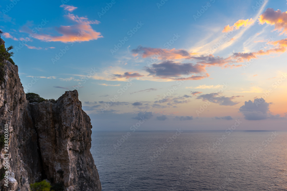 Greece, Zakynthos, Perfect red sunset sky over the cliffs and endless ocean water horizon Greece, Zakynthos, Perfect red sunset sky over the cliffs and endless ocean water horizon