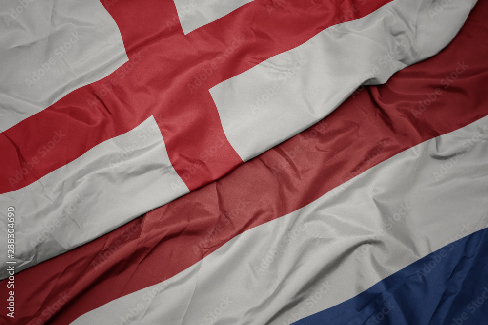 waving colorful flag of netherlands and national flag of england. waving colorful flag of netherlands and national flag of england.