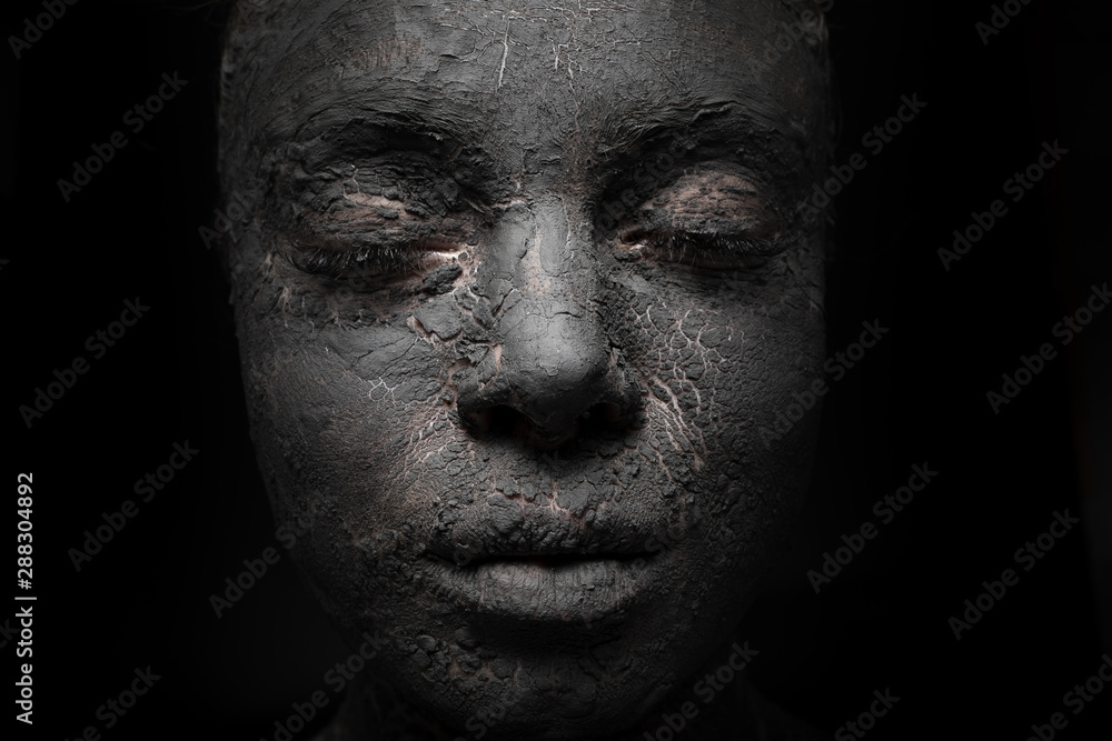 close up woman face with cracked clay skin cover
