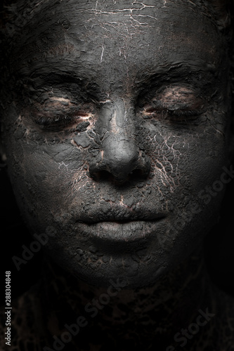close-up woman face with black clay mask
