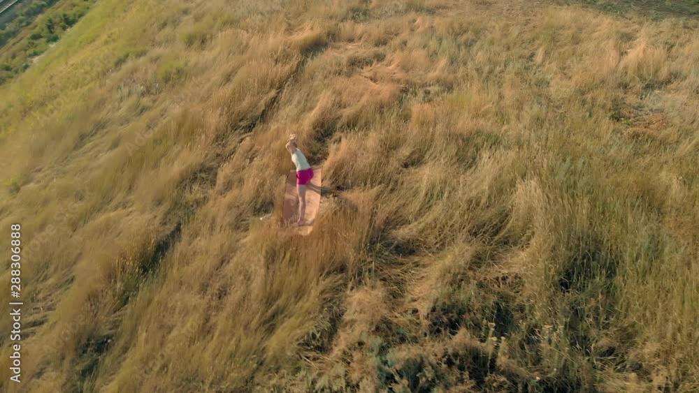 Young woman doing sports outdoors, yoga. aerial video