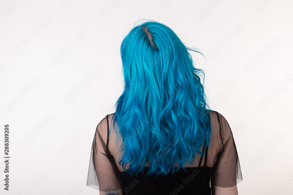 Naklejka premium People and fashion concept - Beautiful woman with blue hair posing over white background, back view