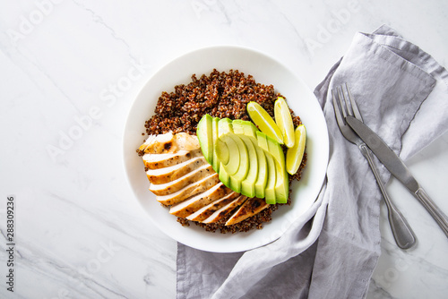 Healthy dish with quinoa, chicken, avocado, lime on marble background top view. Food and health. Superfood meal.