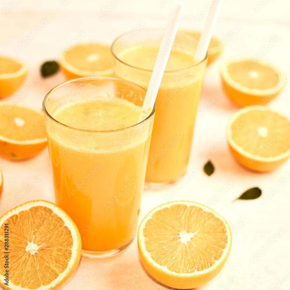 freshly squeezed orange juice in glasses on the kitchen table with slices of oranges, concept of diet and healthy lifestyle freshly squeezed orange juice in glasses on the kitchen table with slices of oranges, concept of diet and healthy lifestyle
