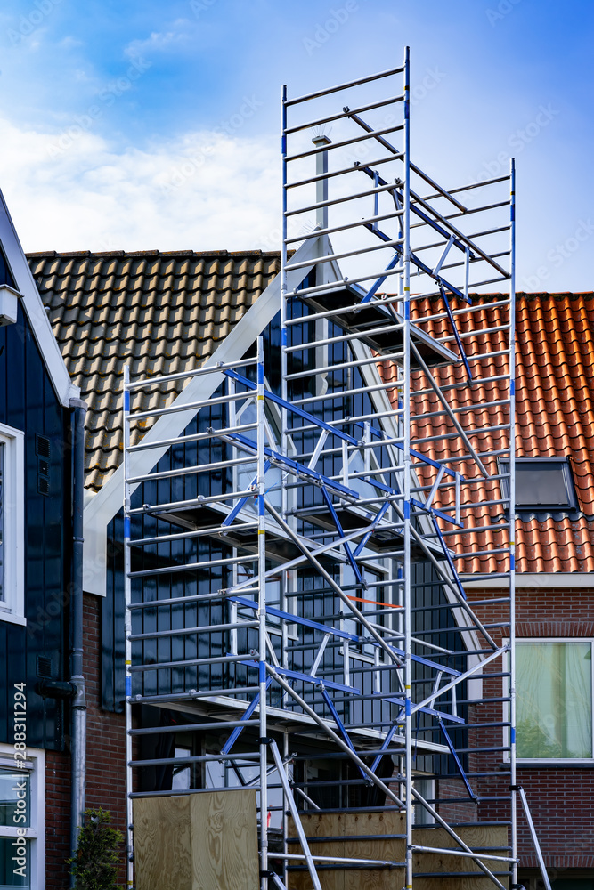 Obraz premium Scaffolding on a small brick house with wood paneling in Netherlands