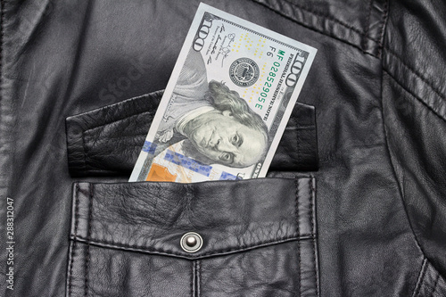 one hundred dollar bill in the pocket of leather jacket