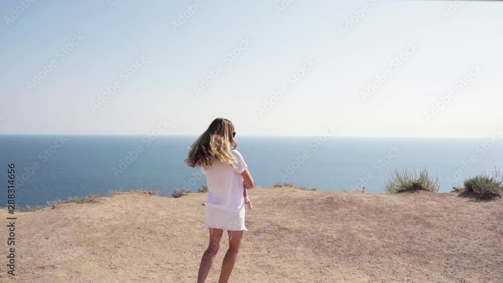 Mother and little child standing together near sea Mother and little child standing together near sea