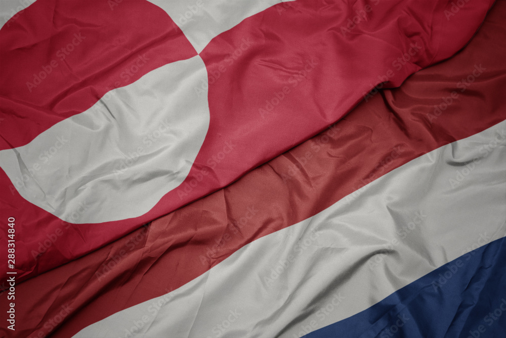 waving colorful flag of netherlands and national flag of greenland. waving colorful flag of netherlands and national flag of greenland.