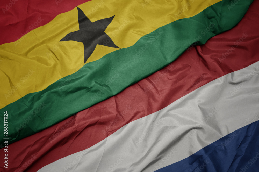 waving colorful flag of netherlands and national flag of ghana. waving colorful flag of netherlands and national flag of ghana.