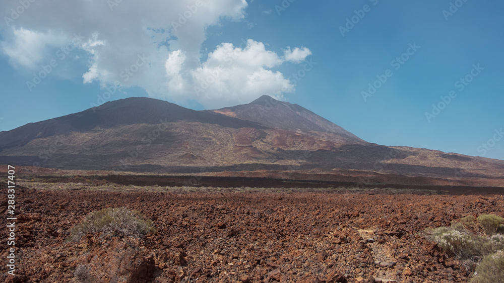 Pico del Teide and Pico Viejo in Teide National Park surrounded by the arid landscape created by volcanic eruptions: igneous rocks, solidified lava and volcanic ash, in Tenerife, Canary Islands, Spain