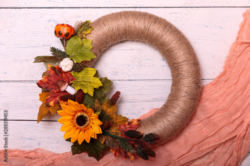 Handmade autumn flower wreath on rustic wooden fence with velvet material photo
