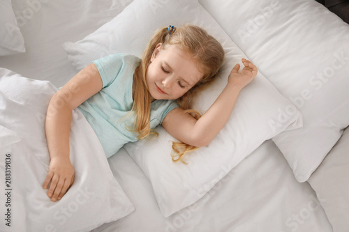 Portrait of cute little girl sleeping in large bed, above view