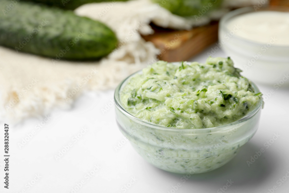 Handmade cucumber face mask in glass bowl on white table Handmade cucumber face mask in glass bowl on white table