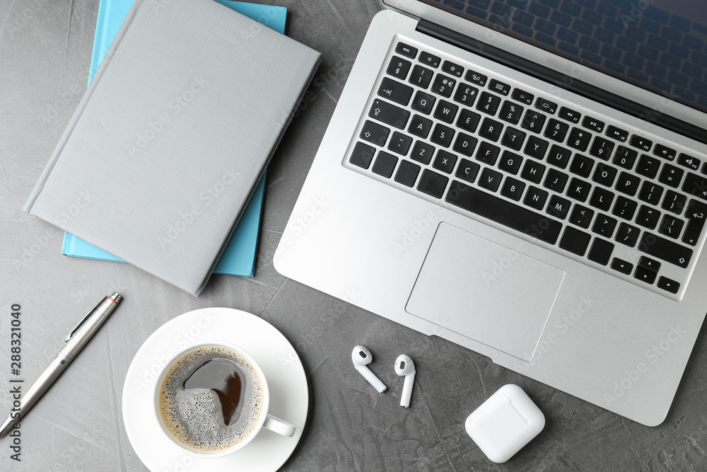 Flat lay composition with earphones and laptop on grey table Flat lay composition with earphones and laptop on grey table