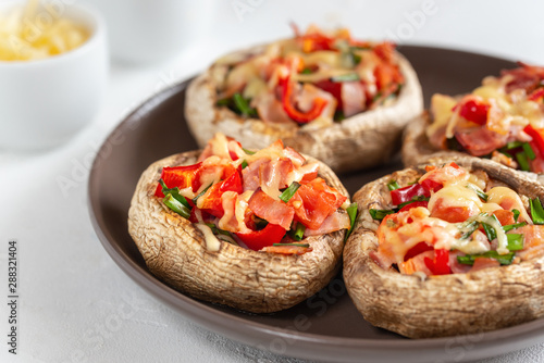 Mushrooms stuffed with bacon, tomato, red pepper, chives and cheese.