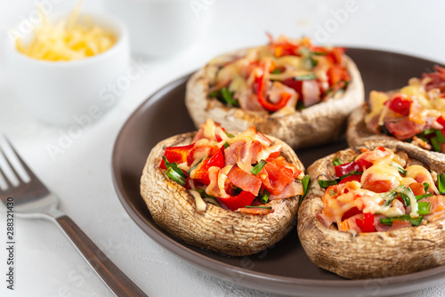 Mushrooms stuffed with bacon, tomato, red pepper, chives and cheese.
