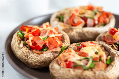 Mushrooms stuffed with bacon, tomato, red pepper, chives and cheese.