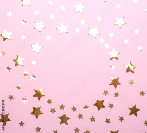 Frame made of confetti stars with space for text on pink background, top view. Christmas celebration