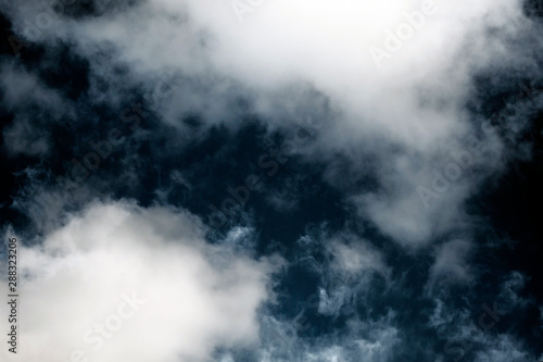 White fluffy clouds on a dark background