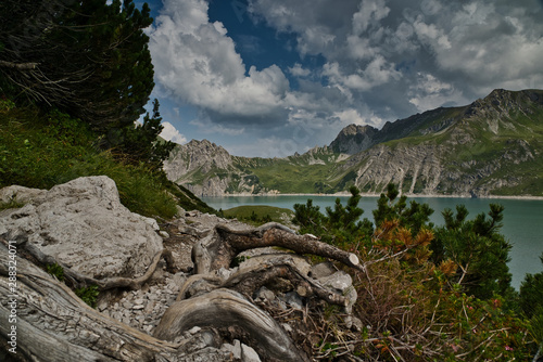 Obraz na płótnie Wanderweg und Wurzeln vor See in den Alpen w salonie
