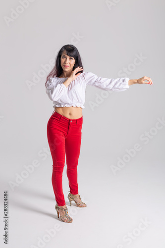 Latina dance, strip dance, contemporary and bachata lady concept - Woman dancing improvisation and moving her long hair on a white background © satura_