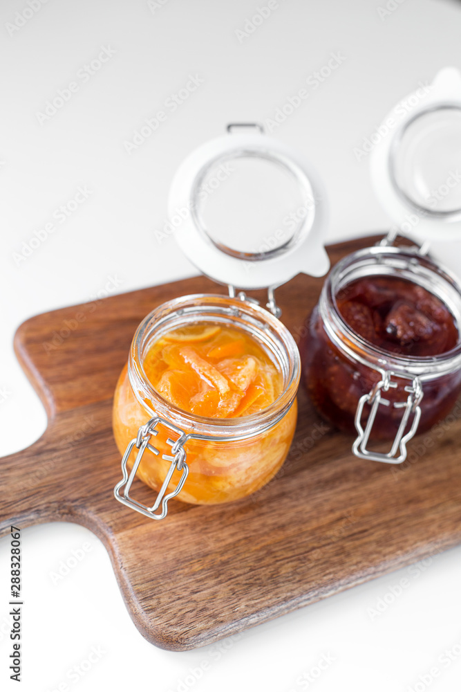open jars with different jam on a wooden board open jars with different jam on a wooden board