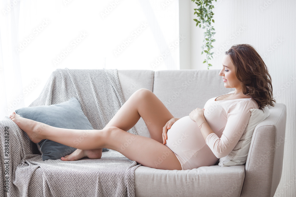 Attractive young woman expecting her baby to born. Beautiful pregnant woman indoors. Expectant at home. Attractive young woman expecting her baby to born. Beautiful pregnant woman indoors. Expectant at home.
